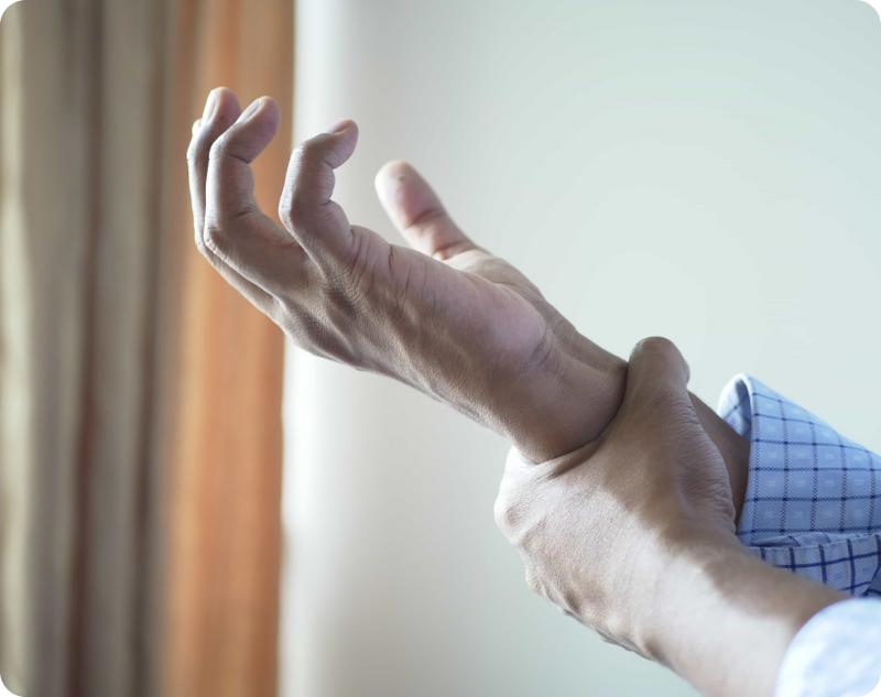 A senior man is examining his trembling hand, wondering if Essential Tremor turns into Parkinson's over time.