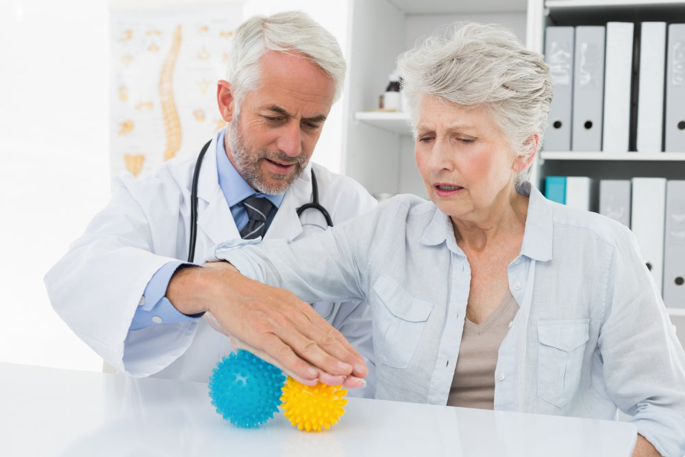Essential Tremor treatment options include a doctor guiding a senior patient using stress-relief balls.
