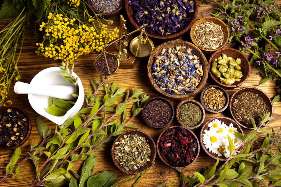 Herbs and natural remedies for essential tremor treatment, displayed on a wooden table.