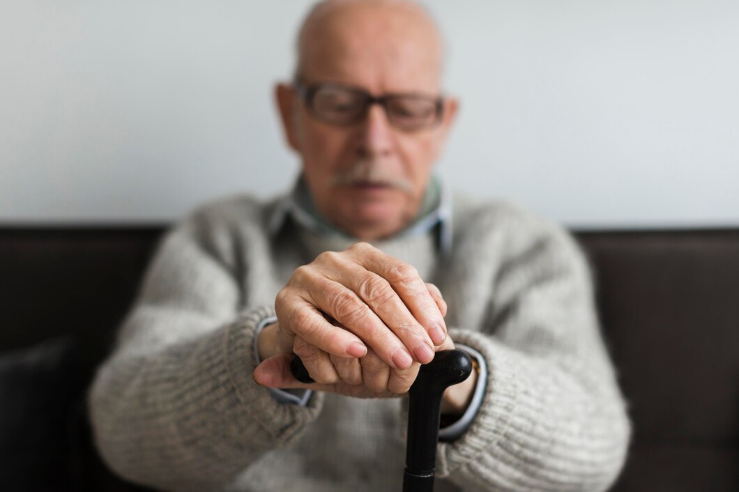 Elderly man with trembling hands due to Parkinson’s.