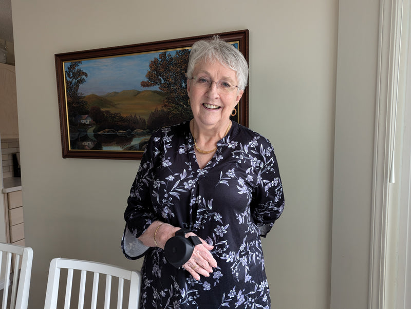 Smiling woman at home wearing the Steadi-3 Plus on her hand